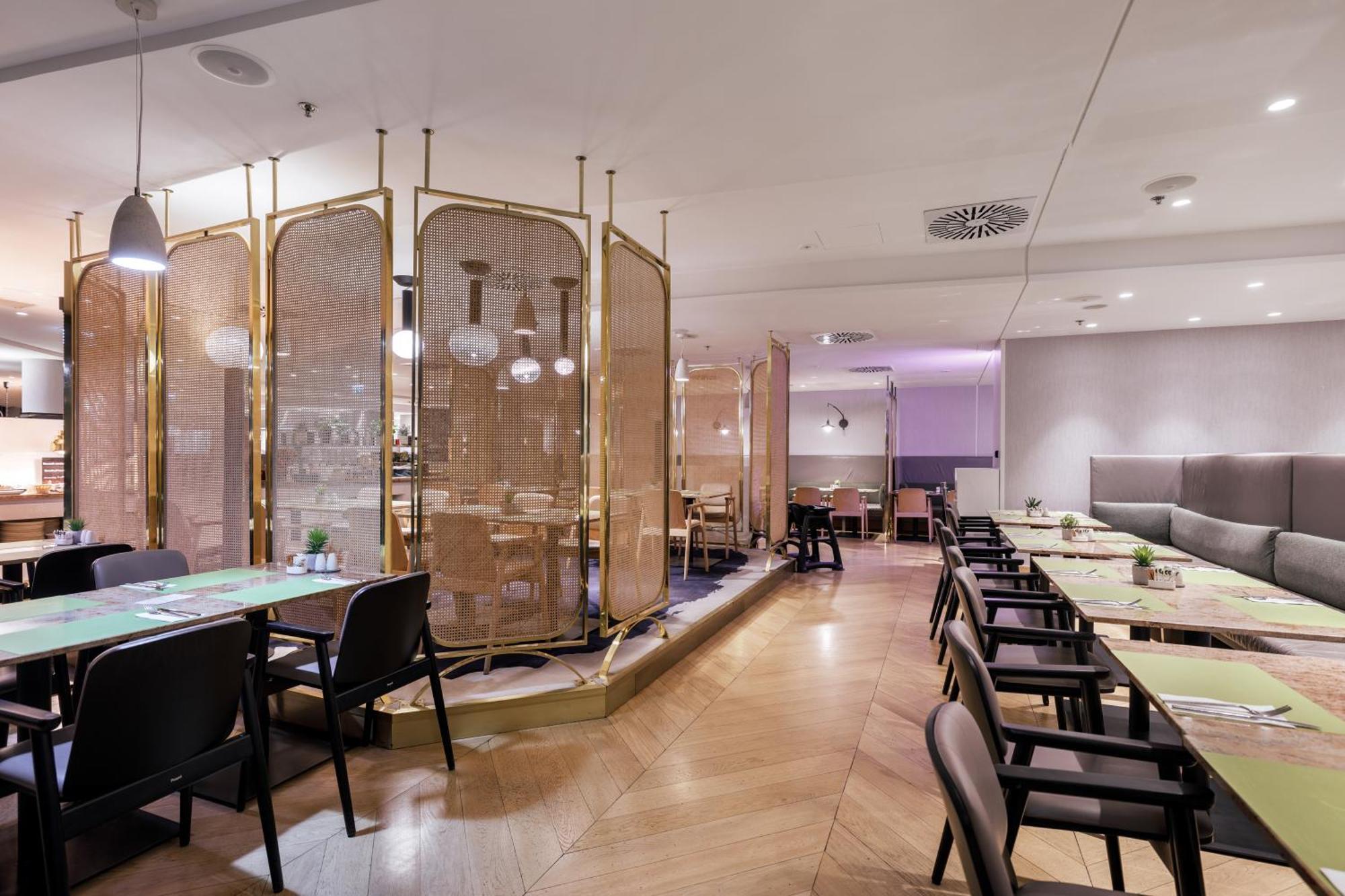Radisson Blu Resort Świnoujście Екстериор снимка The photo depicts a modern restaurant interior. It features a layout with several tables and chairs arranged in an organized manner. There is a decorative partition made of delicate mesh or fabric, providing some privacy between different dining area