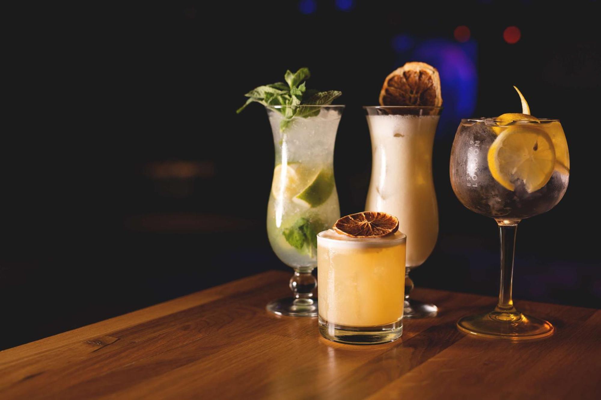 Radisson Blu Resort Świnoujście Екстериор снимка The photo showcases a collection of four different cocktails displayed on a wooden table. 

1. **Mojito**: A tall glass filled with lime slices, mint leaves, and a clear liquid, likely rum-based, garnished with fresh mint.
2. **Creamy Cocktail**: A s