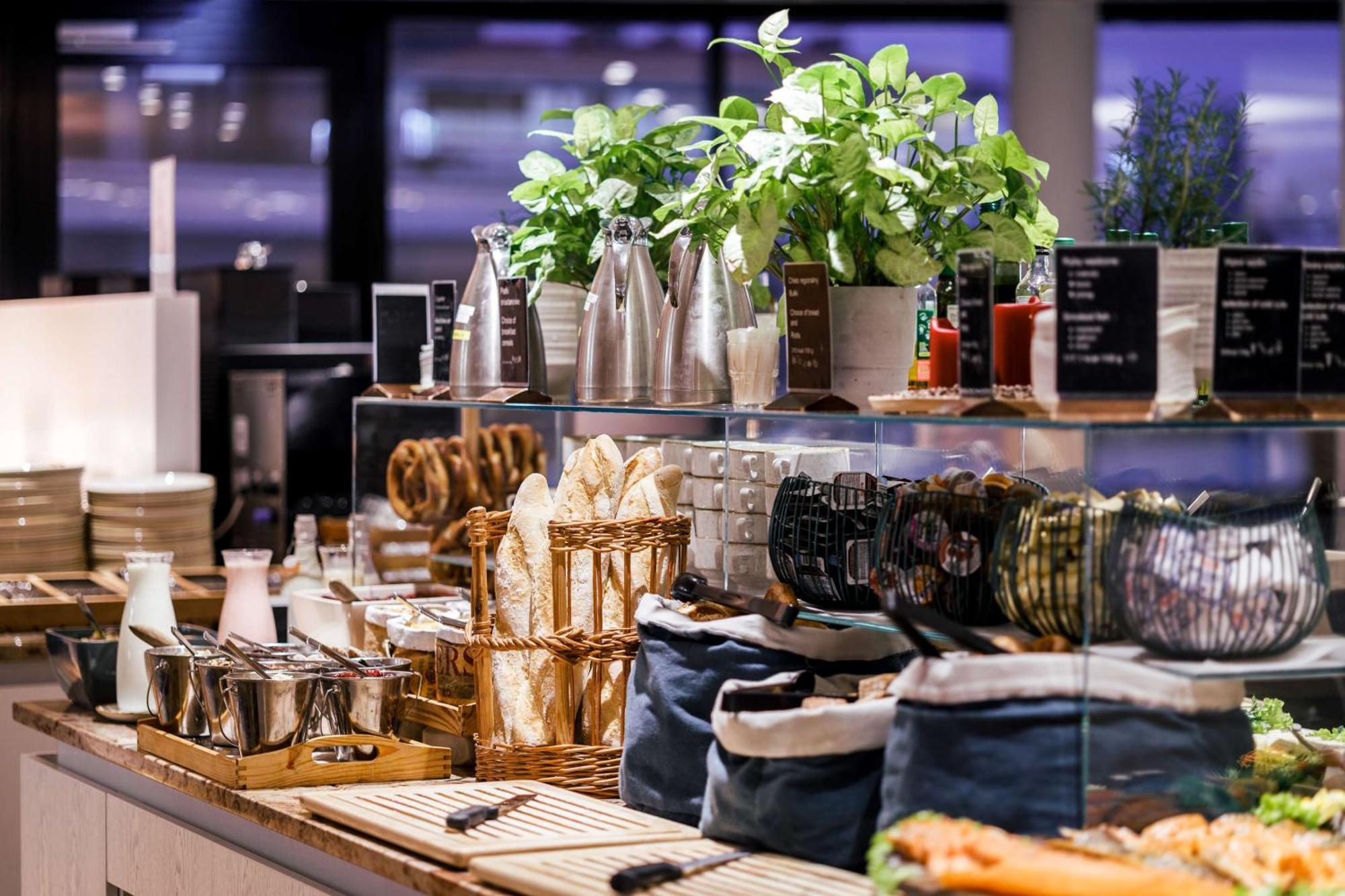 Radisson Blu Resort Świnoujście Екстериор снимка The photo depicts a beautifully arranged buffet or food display area. It features various items such as:

- Several glass or metal containers, possibly holding beverages or condiments.
- Fresh greenery in pots, suggesting a focus on natural elements.