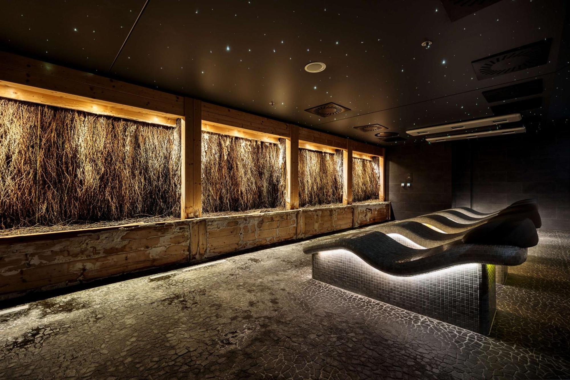 Radisson Blu Resort Świnoujście Екстериор снимка The photo depicts a modern, serene spa or relaxation space. It features several wooden-framed windows that showcase natural elements, possibly dried grass or plants, creating a calming atmosphere. The walls are dark, and the ceiling may have lights r