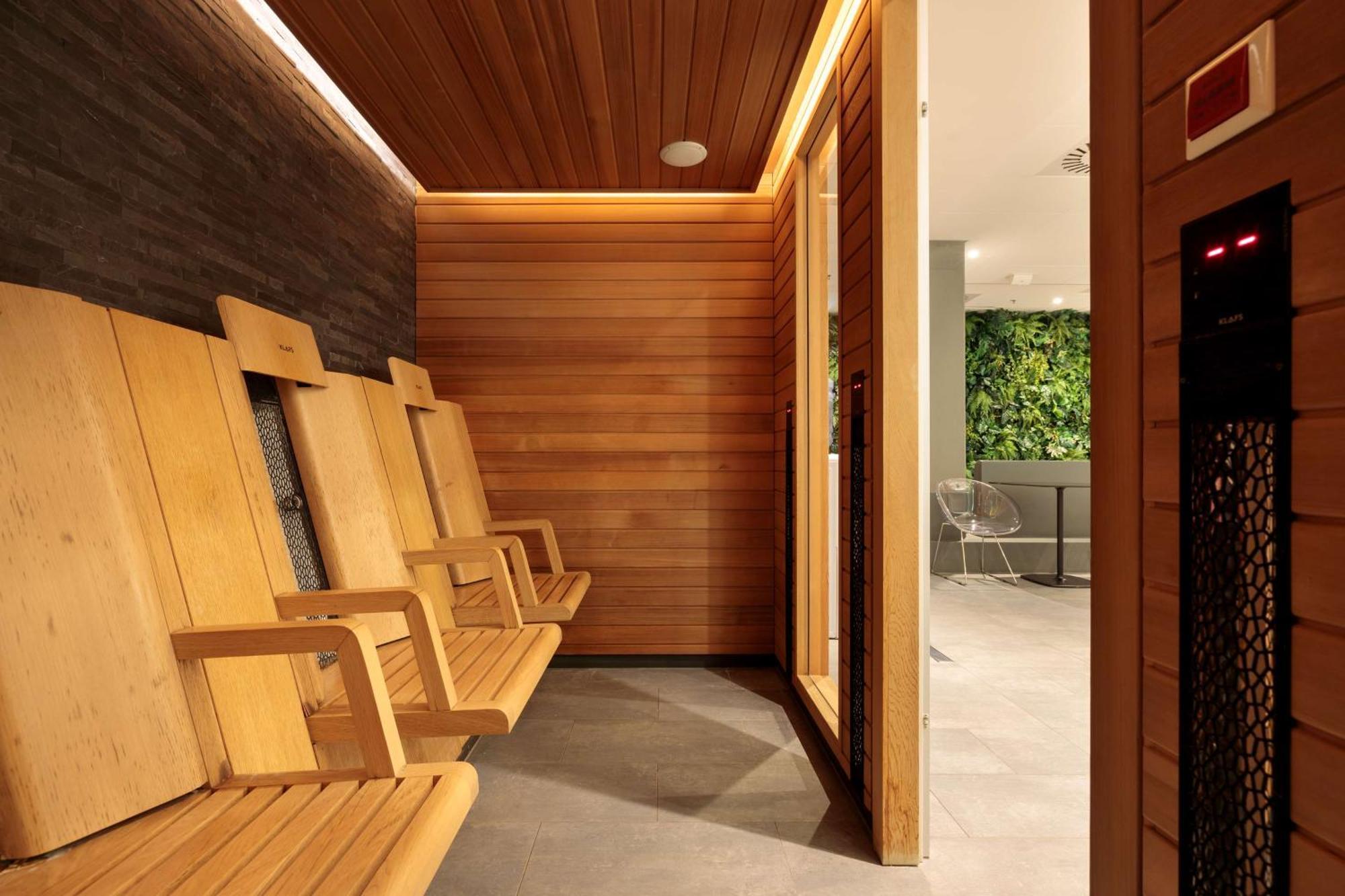 Radisson Blu Resort Świnoujście Екстериор снимка The photo shows a sauna area featuring wooden benches arranged along the walls. The interior is designed with natural wood paneling and has a warm, inviting ambiance. There is a glass door visible, which likely leads to another space, and some greene