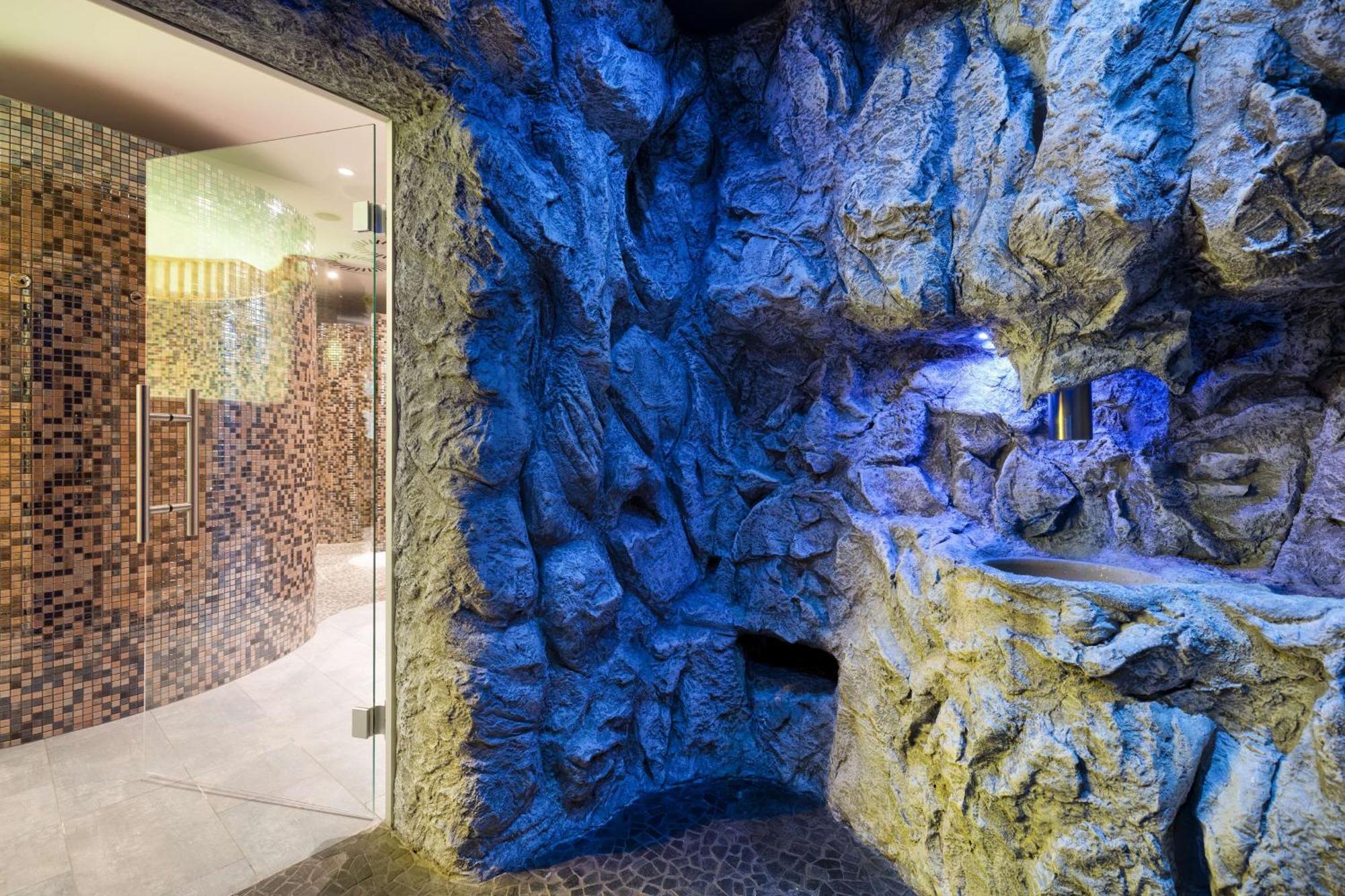 Radisson Blu Resort Świnoujście Екстериор снимка The photo shows a spa-like environment with a cave-like design. The walls are styled to resemble natural rock formations, featuring textures and colors that suggest a stone surface. Soft blue lighting highlights the contours of the rocks, creating a 